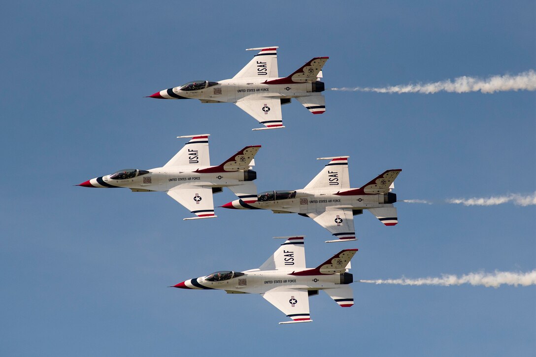Four red, white and blue F-16 Fighting Falcons fly in a diamond formation.