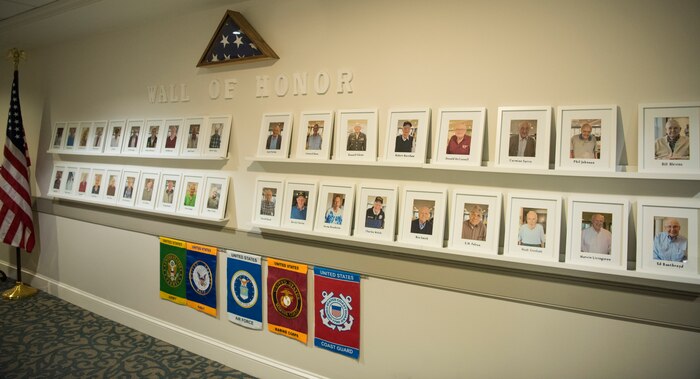 Vietnam, World War II and military veterans’ photos line the wall at the Somerby of Mount Pleasant, a senior living community, as a display honoring Navy Week in Charleston, S.C.