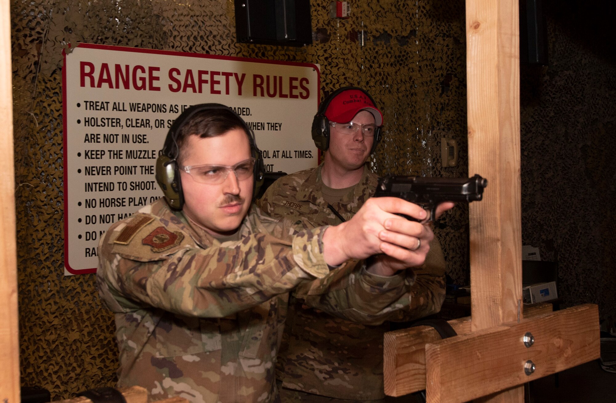 Senior Airman Austin Hopper, 50th Security Force Squadron resource and logistics, conducts a line of fire as Senior Airman Spencer Thorpe, 50th Security Forces Squadron combat arms instructor, provides coaching as range master at the 50th Security Forces shooting range at Schriever Air Force Base, Colorado, March 8, 2019. The combat arms instruction team at Schriever is responsible for ensuring members of the 50th SFS are proficient in the various weapons systems they can uses in their everyday duties. (U.S. Air Force Photo by Staff Sgt. Matthew Coleman-Foster)