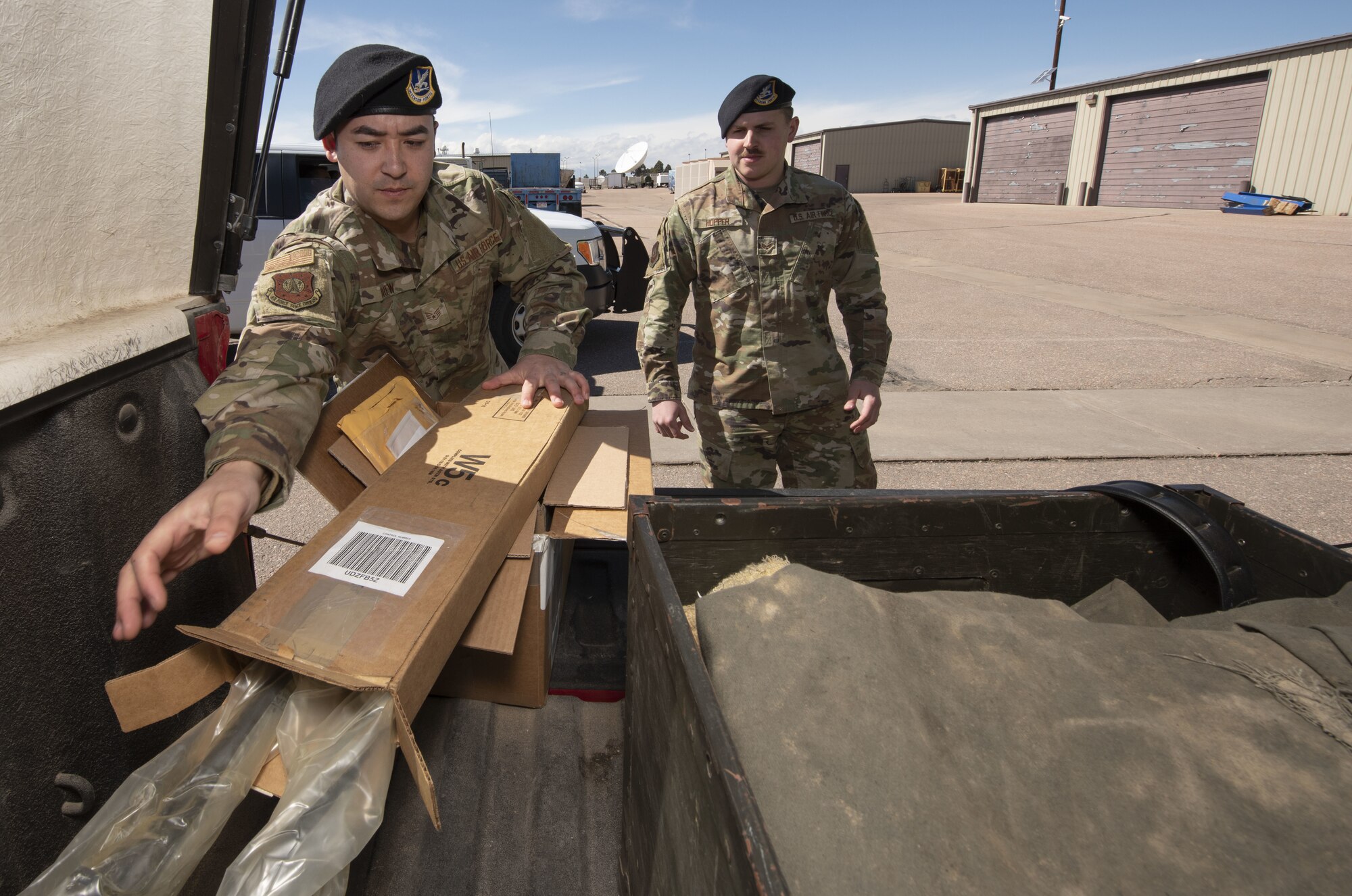 Staff Sgt. Garrett Brew, 50th Security Forces Squadron combat arms instructor, loads a shipment of rifle barrels into a truck as Senior Airman Austin Hopper, 50th Security Force Squadron resource and logistics, looks on at the 50th Security Forces logistics facility at Schriever Air Force Base, Colorado, March 11, 2019. The logistics flight is responsible for acquiring the equipment defenders need for carrying out their mission every day. (U.S. Air Force Photo by Staff Sgt. Matthew Coleman-Foster)