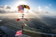two Soldiers parachuting with American and united kingdom flags flying.
