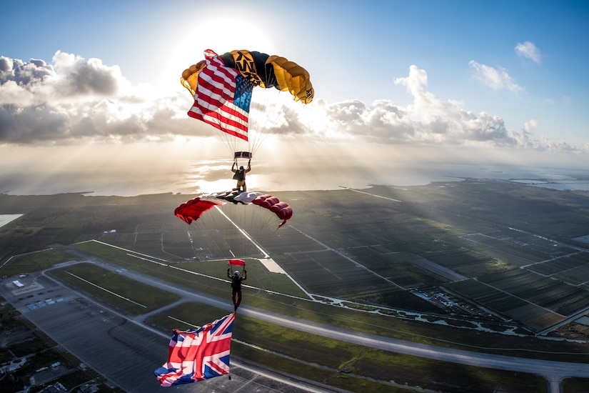 two Soldiers parachuting with American and united kingdom flags flying.