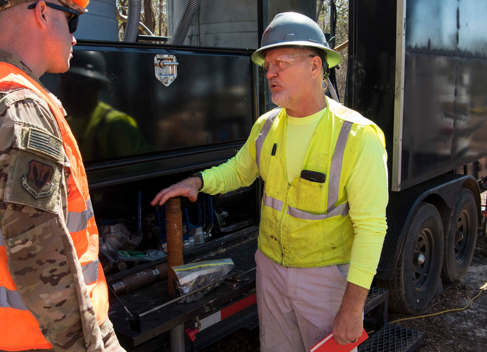 U.S. Air Force Maj. Brandon Goebel, 20th Civil Engineer Squadron commander, left, and Gary Simpson, AST Environmental project manager, discuss how the Enhanced Environmental Cleanup Technology, BOS 100® Treatment Barrier is injected at Sans Souci Farm in Sumter, S.C., March 7, 2019.