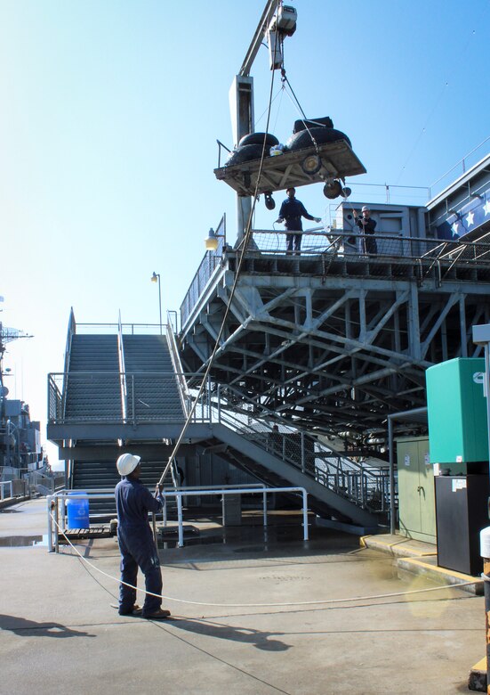 Members of Patriots Point’s maintenance staff use a crane to bring the two main landing gear and nose gear wheel and tire assemblies up to the main deck of the USS Yorktown, where the B-25 is located at the Patriots Point Maritme Museum in Mount Pleasant, S.C.