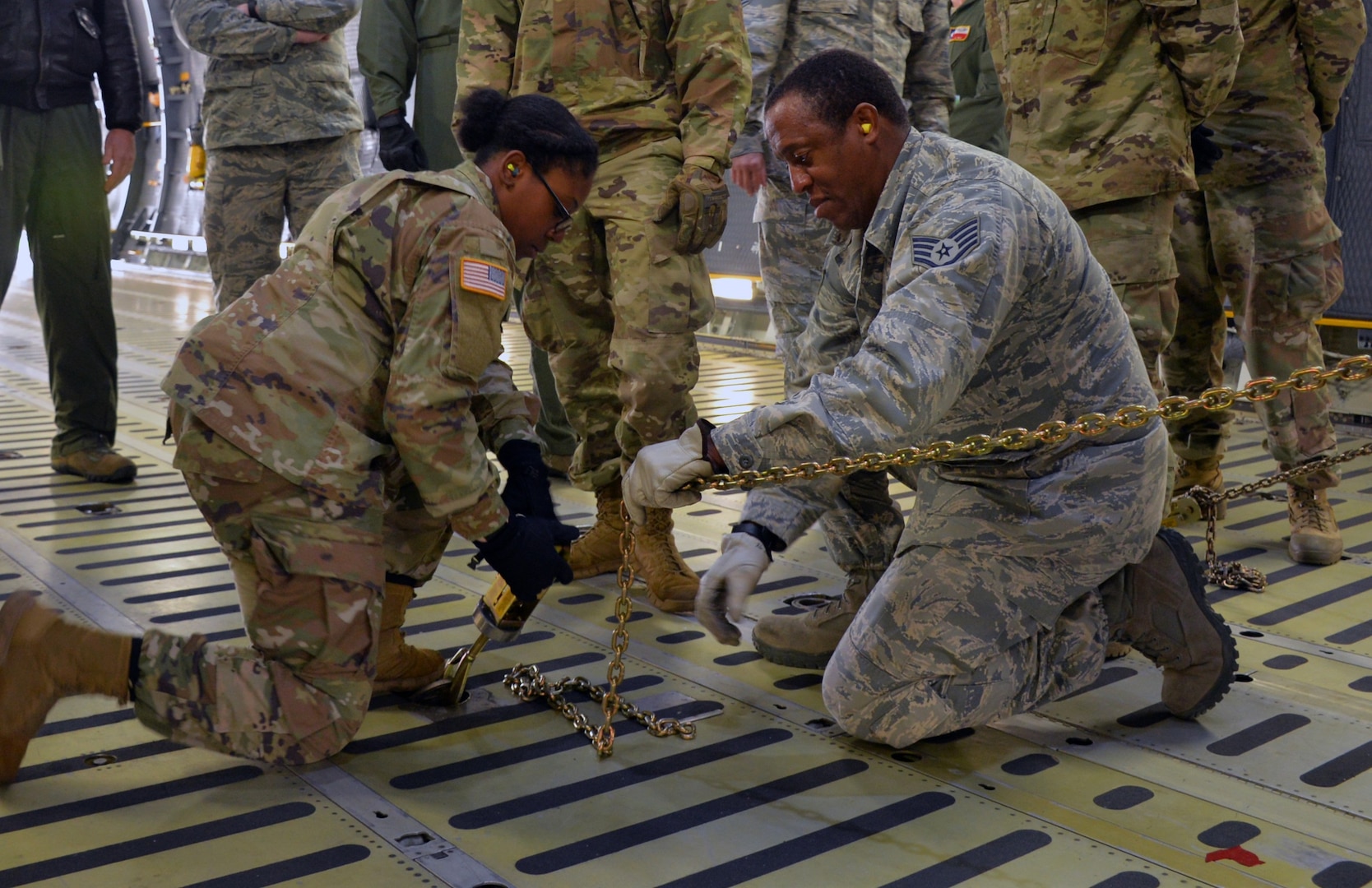 Air Force Staff Sgt. Wayne Burke (right), 26th Aerial Port Squadron air transportation specialist, instructs Army Private 1st Class Shakirra Hoyte (left), 13th Expeditionary Sustainment Command, on how to secure a vehicle for air transportation in a C-5M Super Galaxy aircraft March 2, 2019, at Joint Base San Antonio-Lackland, Texas.