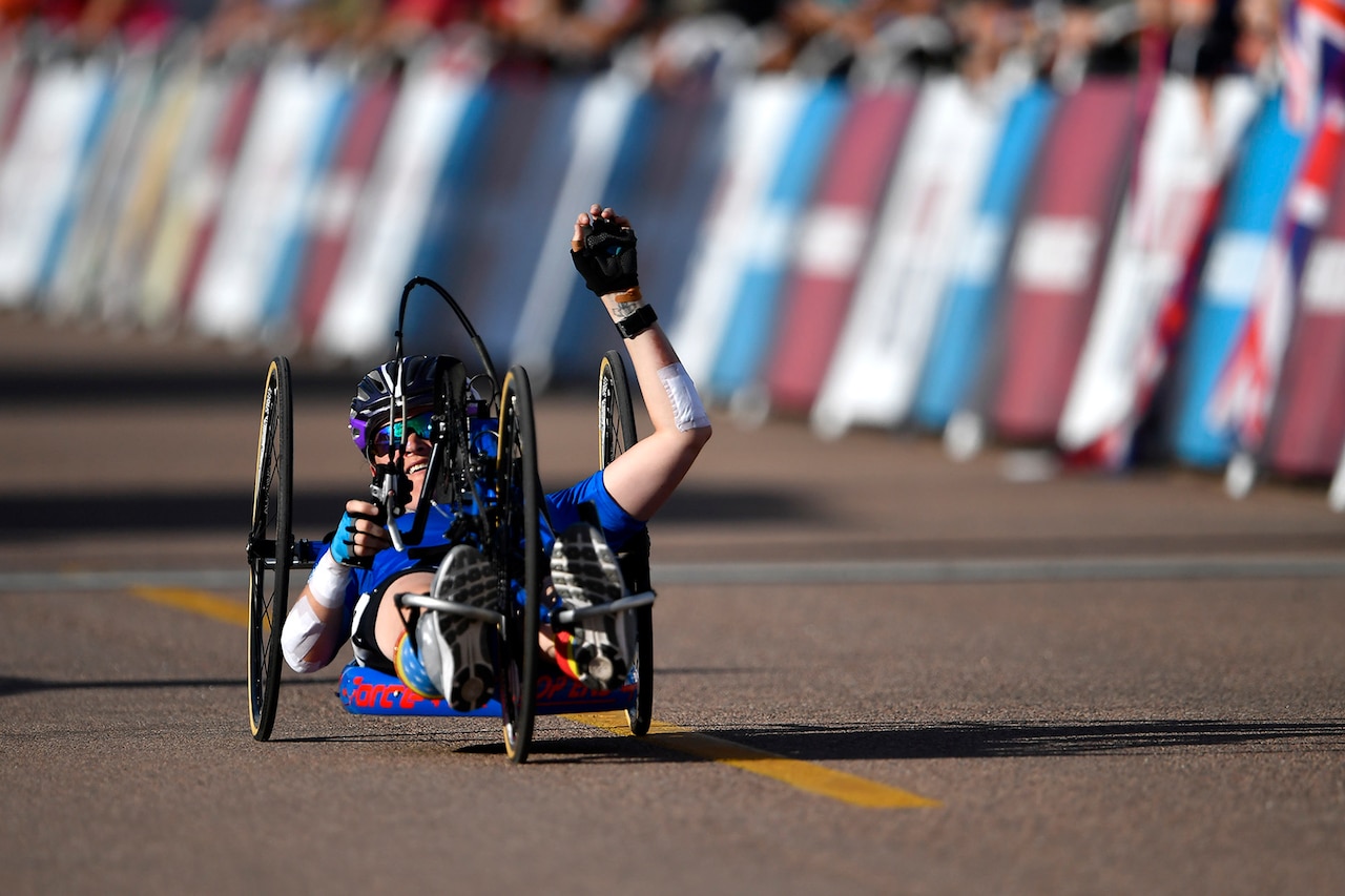 An athlete rides a three-wheel bicycle.