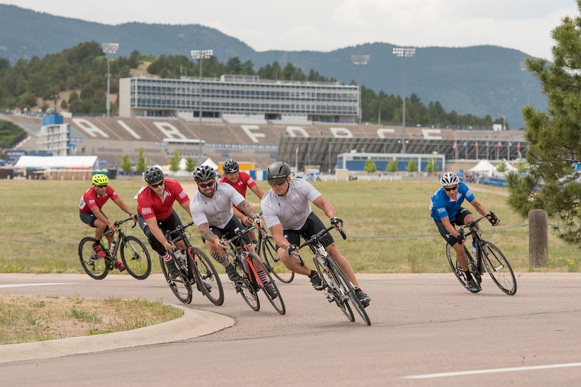 Athletes ride bicycles