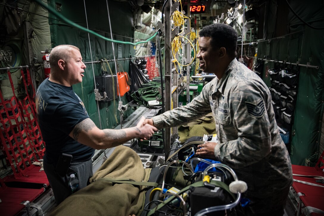 Marine Corps Staff Sgt. (Ret.) Daniel Gilyeat, who lost his left leg in an explosion in July 2005 when his Up Armored Humvee ran over a double-stacked anti-tank mine in Iraq, greets Tech. Sgt. Donald Ennis Jr., NCOIC of the Aeromedical Evacuation Course at the United States Air Force School of Aerospace Medicine. Ennis provided a coin to Gilyeat on behalf of the En Route Care Training Department as they toured one of the C-130 trainers in USAFSAM’s High Bay. Gilyeat was visiting USAFSAM to speak to students at the Aerospace Medicine Primary course March 4. (U.S. Air Force photo/Richard Eldridge)