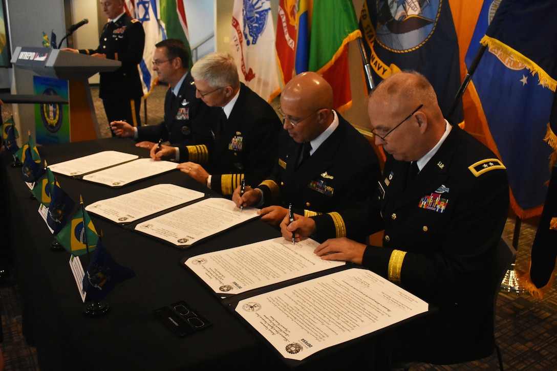 Chief of International Affairs at the Brazil Ministry of Defense, Rear Admiral Guilherme Da Silva Costa(center right) and New York National Guard Adjutant Gen., Maj. Gen. Raymond Shields (right), sign a state partnership agreement, on the U.S.S. Intrepid, Manhattan, N.Y., March 14, 2019.