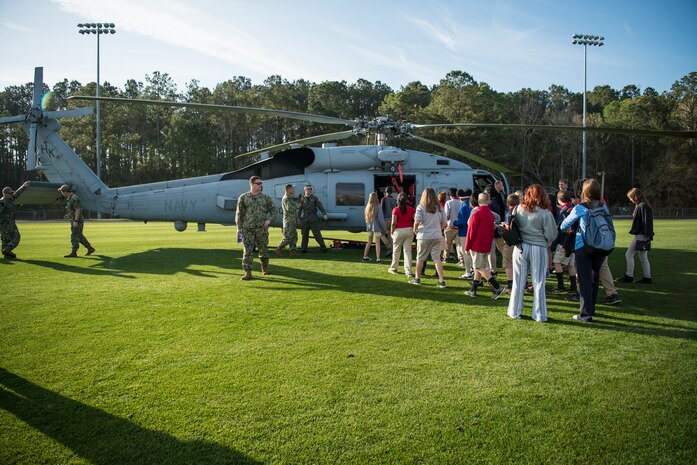 Students gather around the Helicopter Maritime Strike Squadron Four-Zero during a Navy Week school visit March 14, 2019, on John’s Island, S.C.