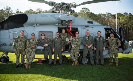 Members of the Helicopter Maritime Strike Squadron Four-Zero stand on the field of St. Johns High School during a Navy Week school visit March 14, 2019, on Johns Island, S.C.
