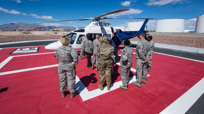 Airmen gather around a helicopter.