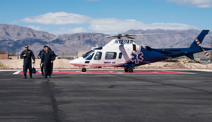 A flight crew walks away from a helicopter.