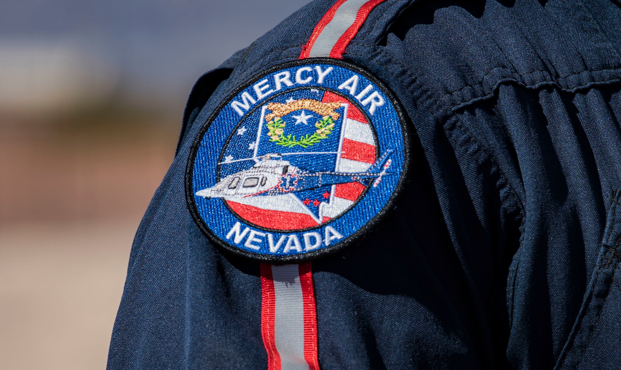 A Mercy Air Nevada patch sits on a flight crew member's shoulder.