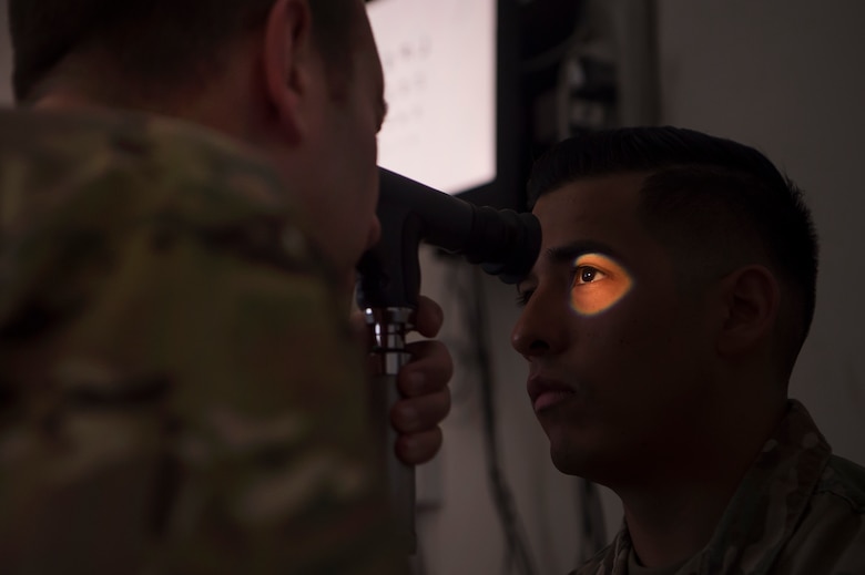 U.S. Air Force Lt. Col. Peter Carra, 379th Expeditionary Medical Group optometry officer in charge, performs an eye exam for a U.S. Soldier, March 9, 2019, at Camp As Sayliyah, Qatar. Carra and Tech. Sgt. Marquita Moore, 379th EMDG optometry noncommissioned OIC, travel to CAS once a week to provide eye care for Soldiers who, in turn, fabricate glasses prescribed for Airmen at Al Udeid Air Base, Qatar, and service members at other deployed locations throughout U.S. Central Command. (U.S. Air Force photo by Tech. Sgt. Christopher Hubenthal)