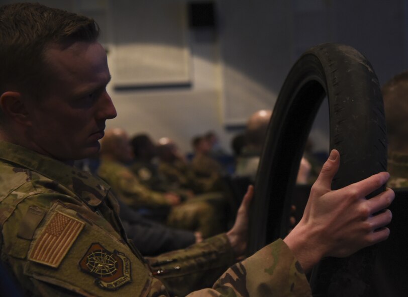 An Airman with the 375th Air Mobility Wing inspects a bald motorcycle tire during the motorcycle riding preseason brief in the Base Theater at Scott Air Force Base, Ill., March 12, 2019. During the briefing motorcycle riders on the installation listened to Motorcycle Safety Representatives as a way to fulfill mandatory training requirements and prep for the upcoming riding season. (U.S. Air Force photo by Airman 1st Class Solomon Cook)
