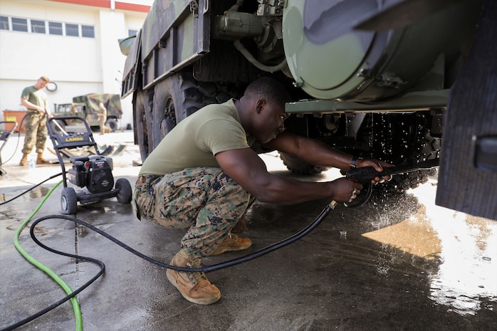 U.S. Marine Corps Lance Cpl. Martin Coggins pressure washes the underside of a Medium Tactical Vehicle Replacement 7-Ton March 13, 2019 on Camp Kinser, Okinawa, Japan. The MTVR 7-Ton is one of many pieces of equipment that will be cleaned, inspected and then shipped for use in Australia by the Marine Rotational Force – Darwin Marine Air-Ground Task Force. Coggins, an electrical engineer with Engineer Maintenance Company, Combat Logistics Battalion 4, 3rd Marine Logistics Group, is a native of Bronx, New York. (U.S. Marine Corps photo by Cpl. Isabella Ortega)