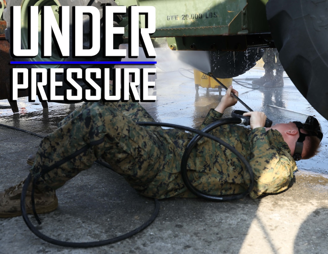 U.S. Marine Corps Lance Cpl. Audie Rooks pressure washes the underside of a backhoe March 13, 2019 on Camp Kinser, Okinawa, Japan. The backhoe is one of many pieces of equipment that are cleaned, inspected and then shipped for use in Australia by the Marine Rotational Force – Darwin Marine Air-Ground Task Force. Rooks, a heavy equipment operator with Heavy Equipment Operations Platoon, Engineer Support Company, 9th Engineer Support Battalion, 3rd Marine Logistics Group, is a native of Hawkinsville, Georgia. (U.S. Marine Corps photo by Cpl. Isabella Ortega)