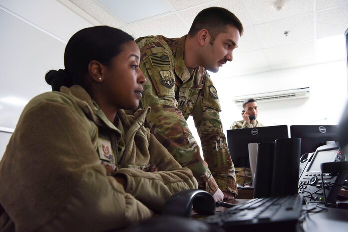 Tech. Sgt. Kathryn Glenn, 380th Expeditionary Logistics Readiness Squadron NCOIC, logistics plans, and Capt. Mark Dellaquila, 380th ELRS Installation Deployment Officer, answers a call about redeployments at Al Dhafra Air Base, United Arab Emirates, Mar. 14, 2019.