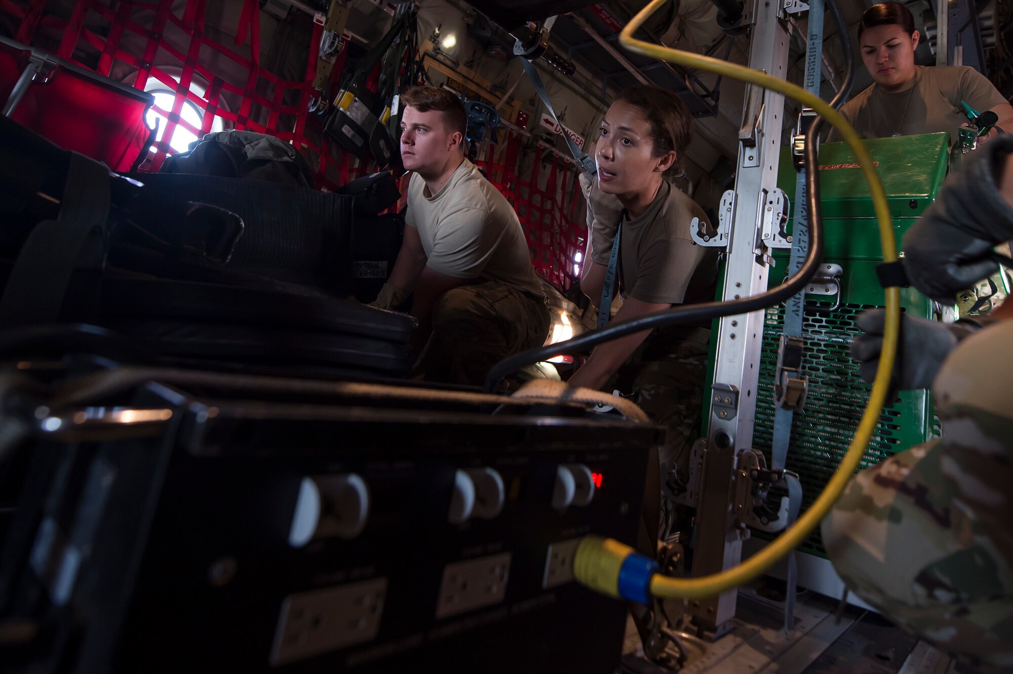 From left, Senior Airman Robert McCabe, 379th Expeditionary Aeromedical Evacuation Squadron (EAES) aeromedical evacuation technician, and Capt. Aline Putnam, 379th EAES flight nurse, fasten a litter and medical equipment into place on a C-130 Hercules at Al Udeid Air Base, Qatar, before a recent aeromedical evacuation mission.