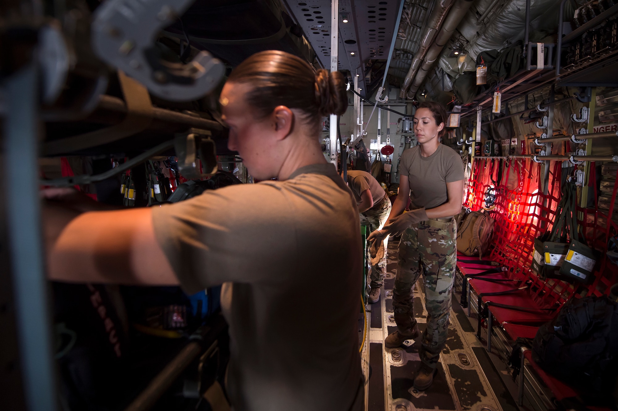 From left, Staff Sgt. Lyndsey Glotfelty, 379th Expeditionary Aeromedical Evacuation Squadron (EAES) aeromedical evacuation technician, and Capt. Aline Putnam, 379th EAES flight nurse, store medical equipment on a C-130 Hercules at Al Udeid Air Base, Qatar, before a recent aeromedical evacuation mission.