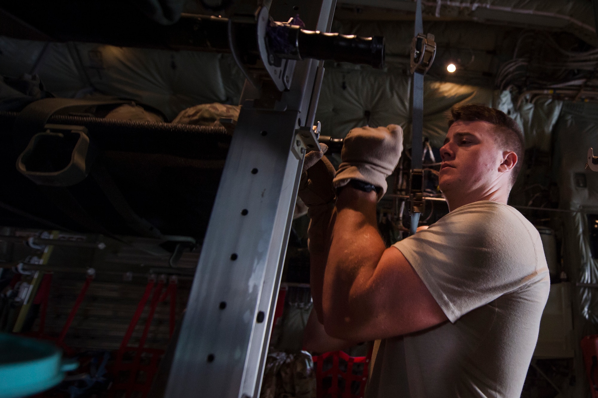 Senior Airman Robert McCabe, left, 379th Expeditionary Aeromedical Evacuation Squadron (EAES) aeromedical evacuation technician, fastens a litter to the inside of a C-130 Hercules at Al Udeid Air Base, Qatar, before a recent aeromedical evacuation mission.