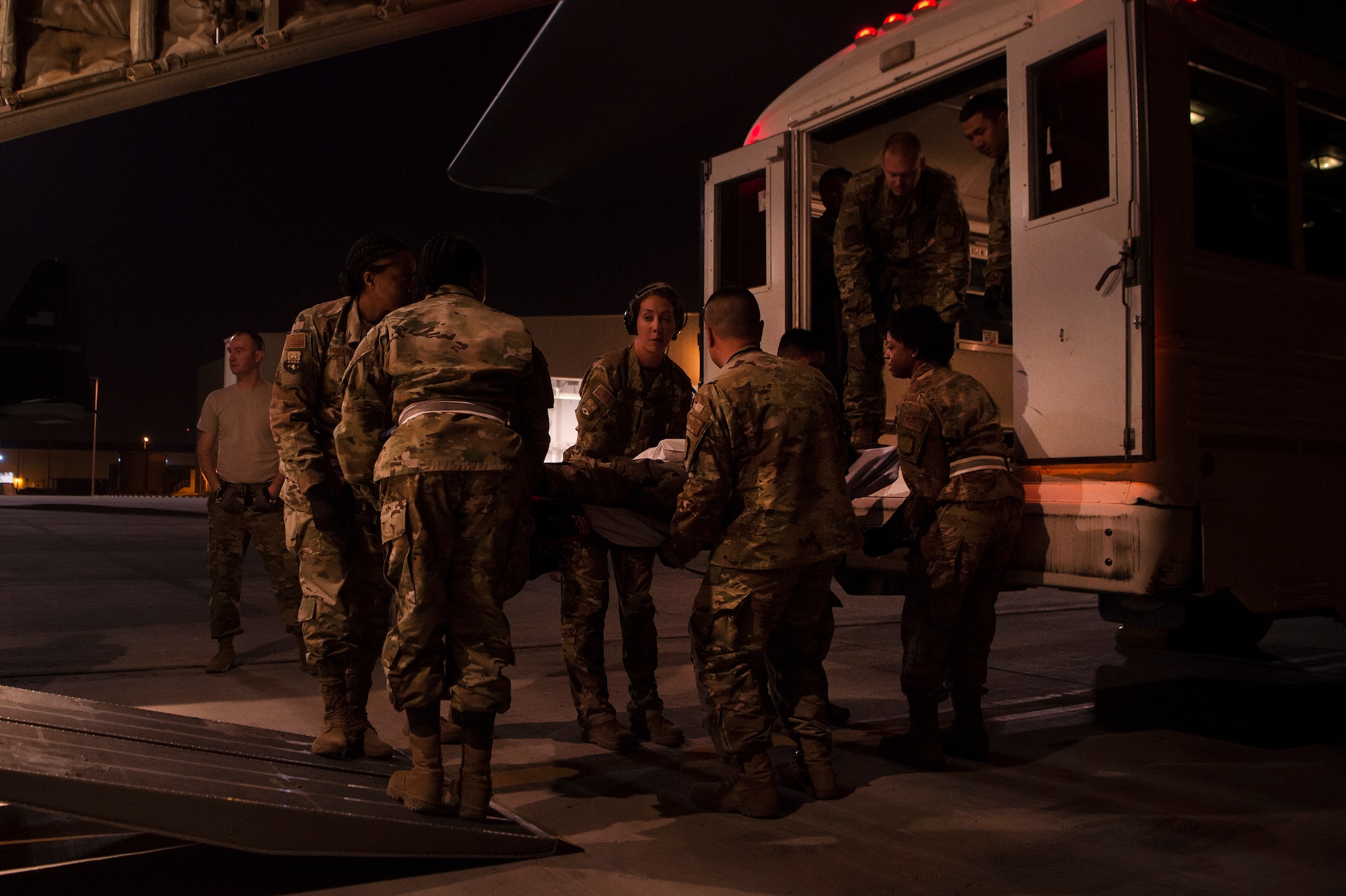 Capt. Aline Putnam, center, 379th Expeditionary Aeromedical Evacuation Squadron (EAES) flight nurse, helps Airmen of the 379th Expeditionary Medical Group’s En Route Patient Staging Facility, move a patient for transport at Al Udeid Air Base, Qatar, after a recent aeromedical evacuation mission.