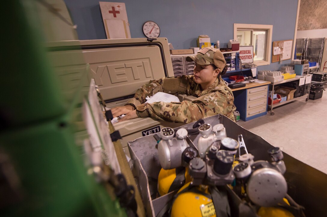 Staff Sgt. Jessica Hakert, 379th Expeditionary Aeromedical Evacuation Squadron (EAES) aeromedical evacuation technician, organizes medical equipment at Al Udeid Air Base, Qatar, before a recent mission.