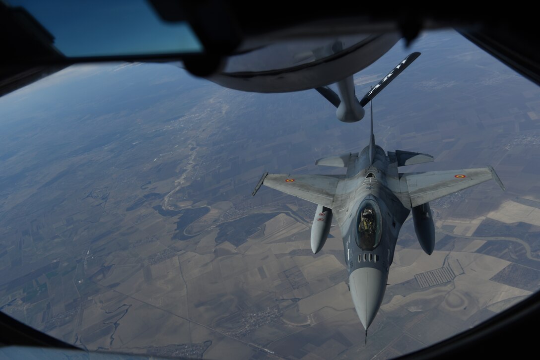 A Romanian air force F-16 receives fuel from a KC-135 Stratotanker from RAF Mildenhall, England during training over the skies of Romania, March 11, 2019. The training was an example of U.S. and NATO allies sharing a commitment to promote peace and stability through developing their relationship and communication process. (U.S. Air Force photo by Airman 1st Class Brandon Esau)