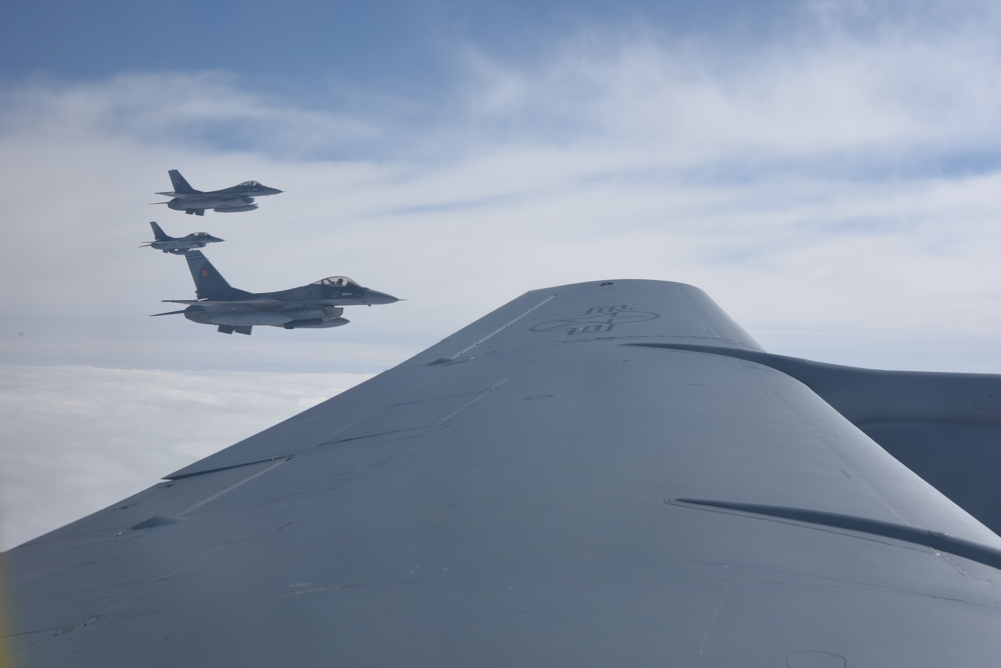 Romania air force F-16s fly in formation with a KC-135 Stratotanker from RAF Mildenhall, England during air refueling training over the skies of Romania March 12, 2019. The training was an example of U.S. and NATO allies sharing a commitment to promote peace and stability through developing their relationship and communication process. (U.S. Air Force photo by Airman 1st Class Brandon Esau)