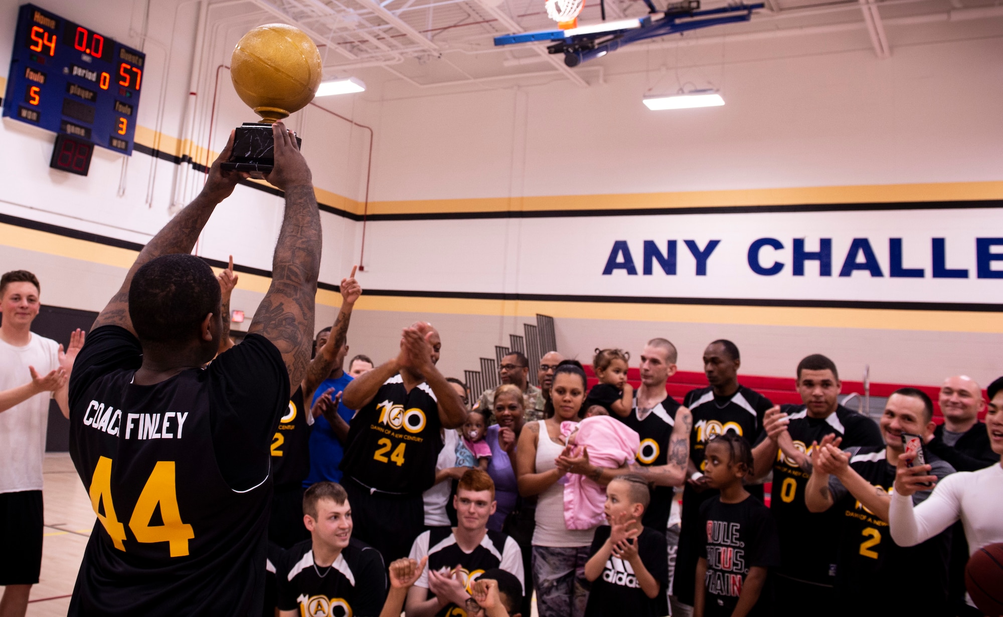 The coach of team U.S. Army Central Command (ARCENT) holds up a trophy following the completion of an intramural basketball championship game at Shaw Air Force Base, S.C., March 14, 2019.