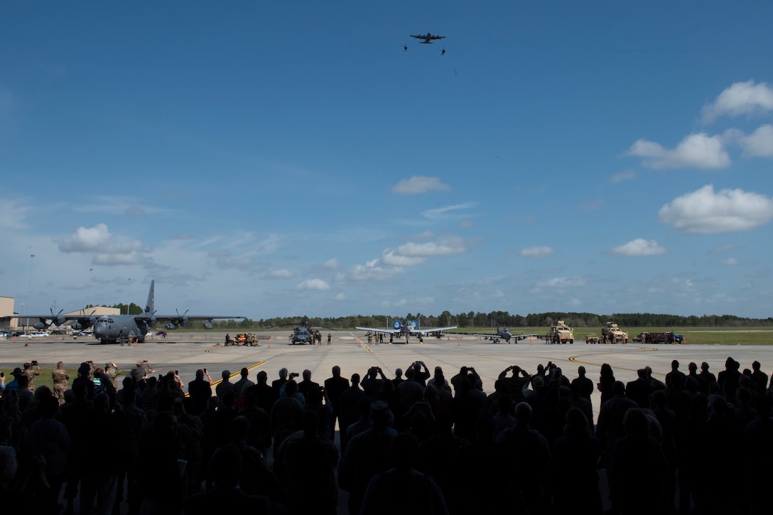 Guests at the W. Parker Greene Celebration of Life ceremony, look up as aircraft fly over on Mar. 14, 2019, at Moody Air Force Base, Ga. The memorial concluded with an HC-130J Combat King II and two HH-60G Pave Hawks in aerial refueling formation and was followed by four A-10C Thunderbolt IIs in a Missing Man formation.(U.S. Air Force photo by Airman 1st Class Joseph P. Leveille)