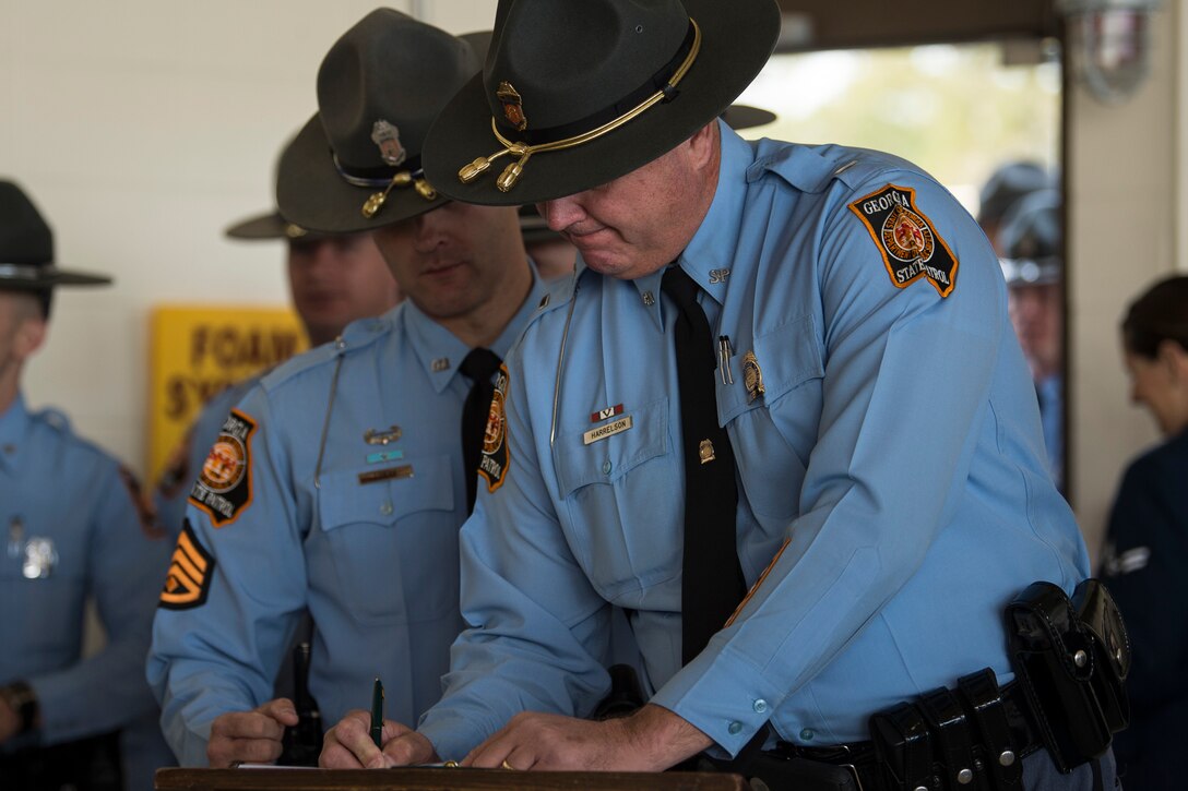 A Georgia State Patrolman signs in before the Celebration of Life ceremony honoring the late Mr. W. Parker Greene, March 14, 2019, at Moody Air Force Base, Ga. Greene, a steadfast Air Force advocate and one of the most influential military civic leaders passed away Dec. 18, 2018. (U.S. Air Force Photo by Senior Airman Janiqua P. Robinson)