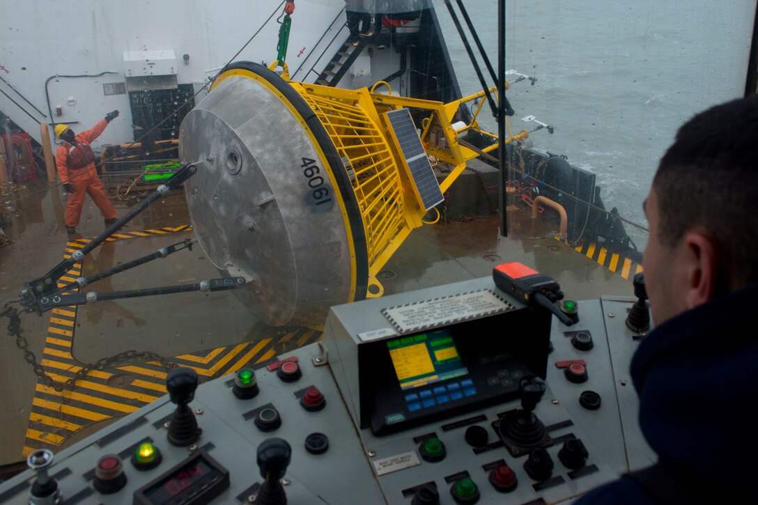 Coast Guardsman directs movement of buoy