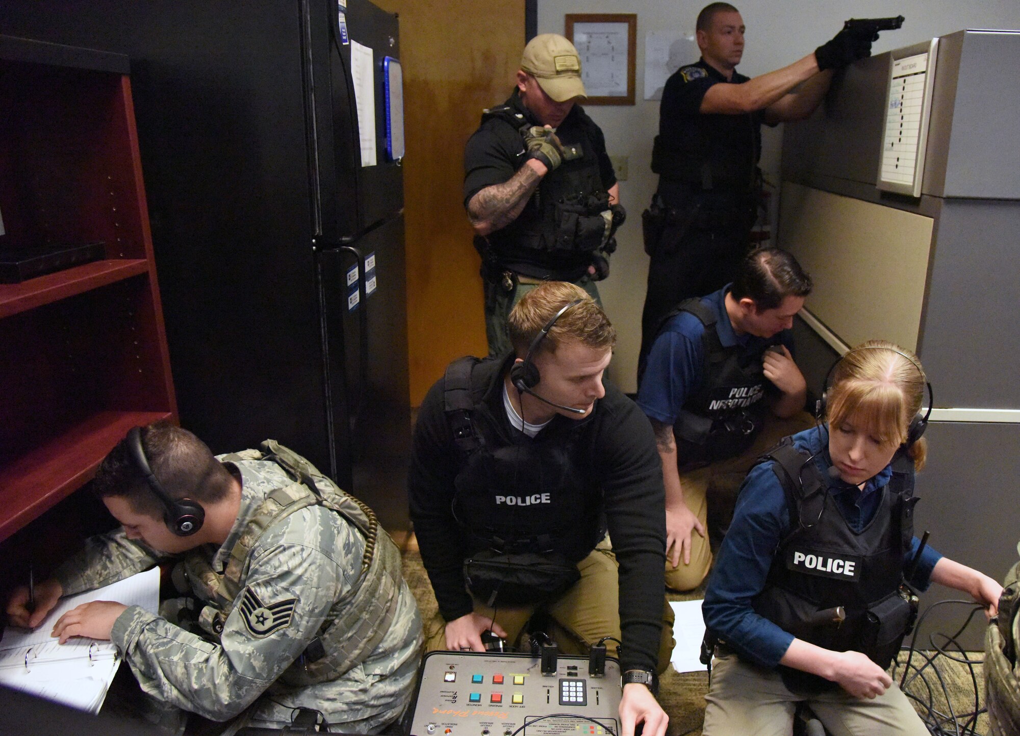 Members of the 81st Security Forces Squadron hostage negotiation team prepare to negotiate with the "shooter" during an 81st SFS active shooter training demonstration at Keesler Air Force Base, Mississippi, March 14, 2019. The scenario included a disgruntled Airman with marital problems and a pending administrative discharge who ran the entry gate which then escalated to an active shooter situation. Leadership attended the event, which is one of several in recognition of the Year Of The Defender, to observe what steps Keesler defenders take during a high intensity situation, such as an active shooter, in preparation for real-world situations. U.S. Air Force Staff Sgt. Kevin Rozas, 81st Security Forces Squadron office of special investigations joint drug enforcement team leader, said that maintaining readiness is the number pone priority for the 81st SFS and it is always good to train in different scenarios because every situation is different so expectations vary, but the training is constant. (U.S. Air Force photo by Kemberly Groue)