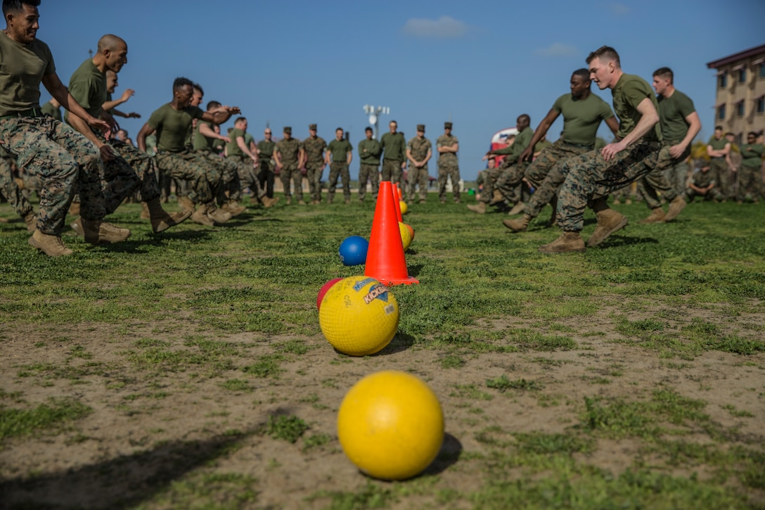 A group of Marines run towards a line of dodge balls.