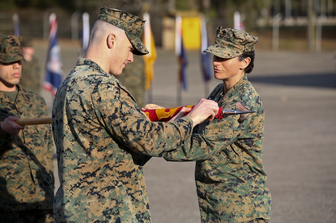 Lt. Col. Kate Murray and Capt. Kevin Buonomo handle the company guidon during Combat Logistics Company 23's realignment ceremony aboard Marine Corps Air Station Beaufort, March 15. Buono is the Company Commander of CLC-23 and Murray is the Commanding Officer of 2nd Maintenance Battalion.