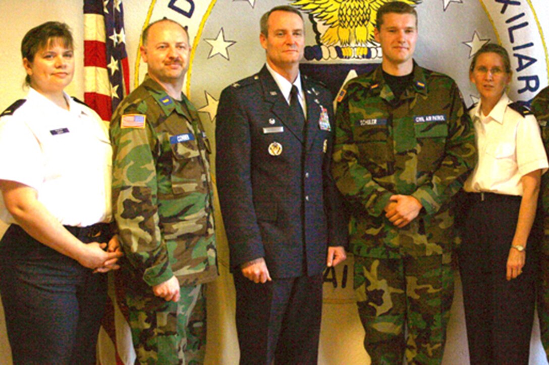 Teresa Conner, now headquarters Civil Air Patrol Montana wing administrator, left, and husband John Conner, now 341st Logistics Readiness Squadron assistant director of logistics and a retired Air Force veteran, second from left, pose for a photo during a Civil Air Patrol event in 2011.