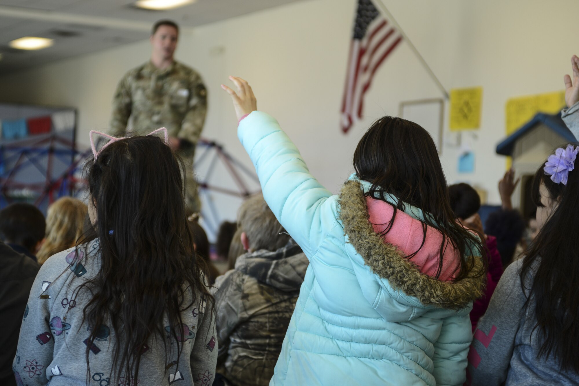 Staff Sgt. Brenden David, 377th Security Forces Squadron Military Working Dog trainer supervisor, answers the questions of students from the Sandoval Academy of Bilingual Education in Rio Rancho, N.M., March 15, 2019. During the MWD demonstration, the team showed the students what and how the dog assists his handler. (U.S. Air Force photo by Staff Sgt. Kimberly Nagle)