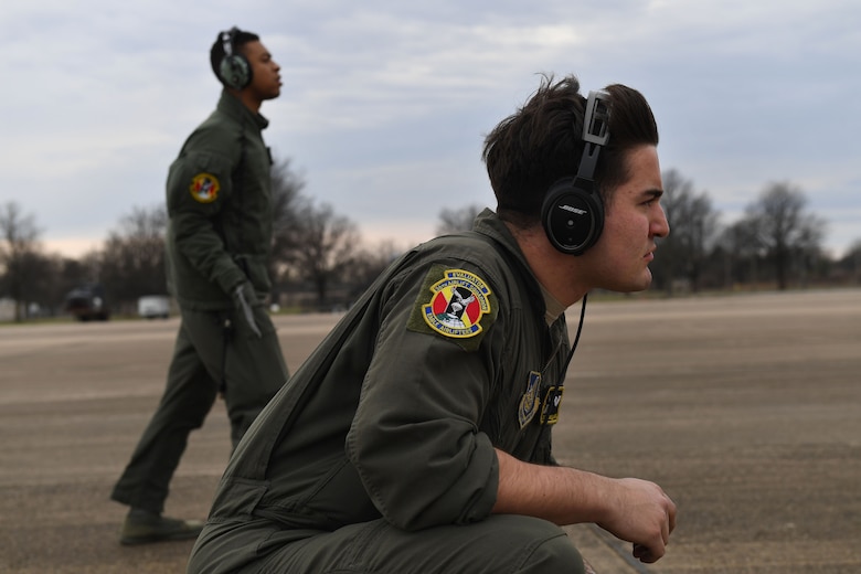 Two Airmen are looking off the edge of the photo.
