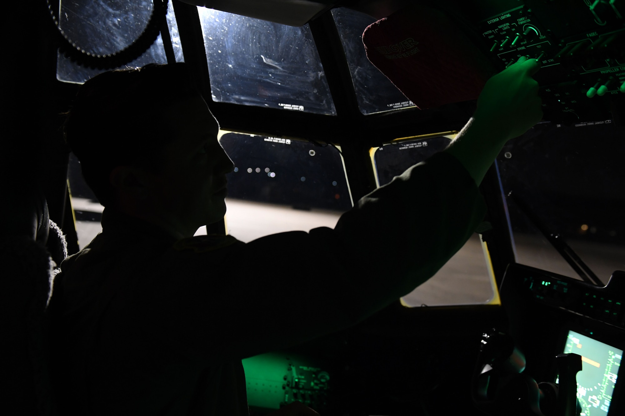 A man is in the flight deck of a C-130J.