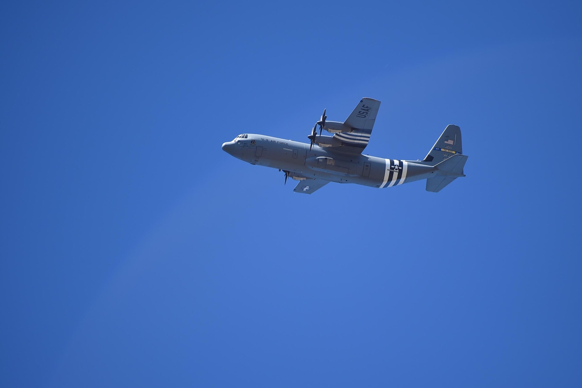 A C-130J flies overhead.