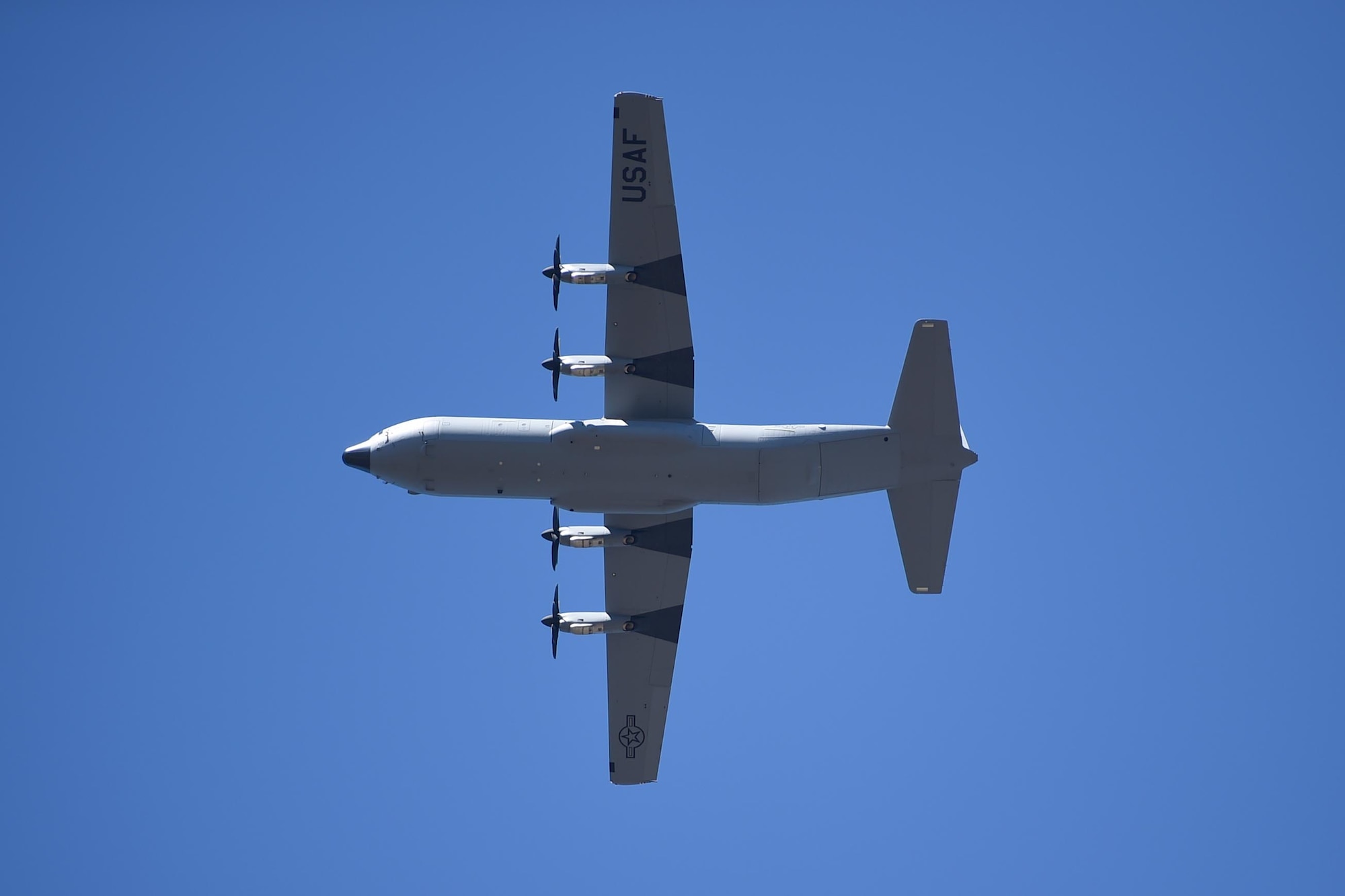 A C-130J flies overhead.