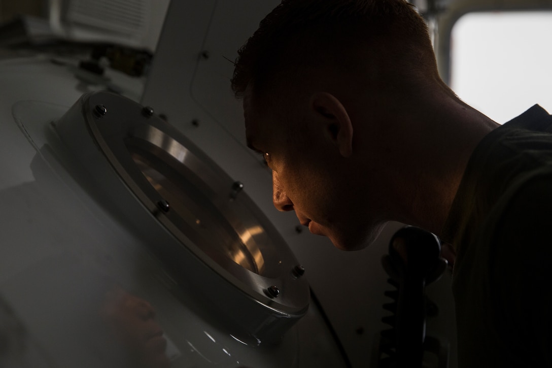 Petty Officer 1st Class Will Crampton, a first class navy diver with 3rd Reconnaissance Battalion, III Marine Expeditionary Force, monitors Marines inside a Standard Navy Double Lock Hyperbaric Recompression Chamber at Camp Schwab, Okinawa, Japan, Jan. 9, 2019. Crampton observed the Marines to ensure their safety while in a SNDLRCS during a training scenario to simulate the pressure felt when diving up to 60 feet in order to enhance combat readiness.