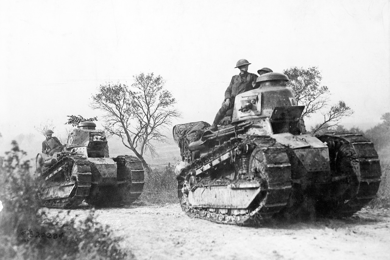 Two tanks roll across ground.