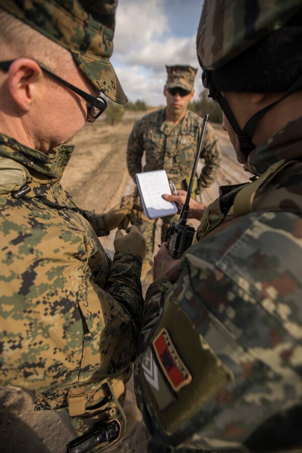 U.S. Marine Corps Warrant Officer Randall J. Walker (left), an explosive ordnance disposal officer attached to Headquarters Battery, 14th Marine Regiment, 4th Marine Division, briefs a current situation report to an Albanian army explosive ordinance disposal team leader during an improvised explosive device scenario at Adazi Training Area, March 9, 2019, during exercise Dynamic Front 19. Exercise Dynamic Front 19 includes approximately 3,200 service members from 27 nations who are observing or participating from Grafenwoehr Training Area, Germany; Riga, Latvia; and Torun, Poland; during March 2-9, 2019. Dynamic Front is an annual U.S. Army Europe exercise focused on the readiness and interoperability of U.S. Army, joint service, and allied and partner nations’ artillery and fire support working together in a multinational environment. (U.S. Marine Corps photo by Cpl. Niles Lee)