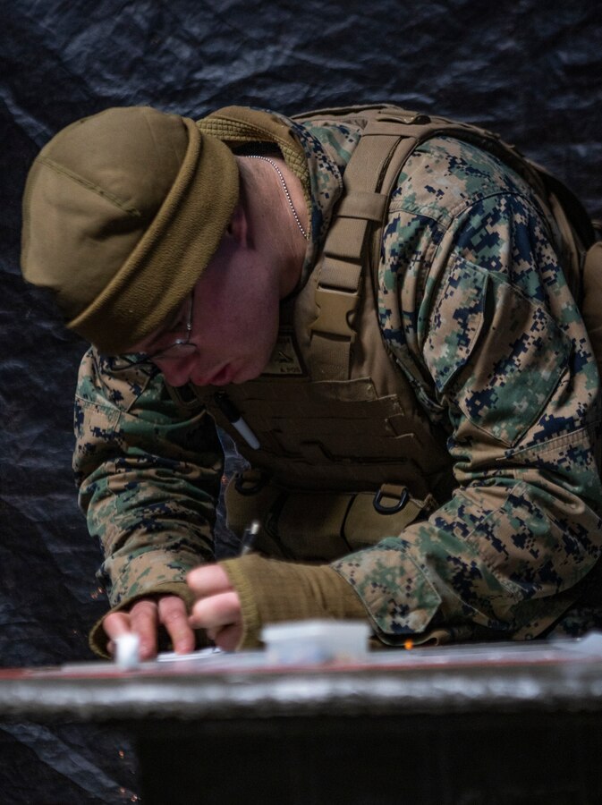 A U.S. Marine with Hotel Battery, 3rd Battalion, 14th Marine Regiment, 4th Marine Division, plots points on a graph at Adazi Training Area, Latvia, March 2, 2019, in support of exercise Dynamic Front 19. Reserve units from across 14th Marine Regiment are the only U.S. Marine Corps units participating in DF19. Approximately 3,200 participants from 27 nations will take part in the live-fire portion of exercise Dynamic Front 19, March 2-9, 2019, at the U.S. Army's Grafenwoehr Training Area, Germany; as well as in Riga, Latvia; and Torun, Poland. (U.S. Marine Corps photo by Sgt. Andy O. Martinez)