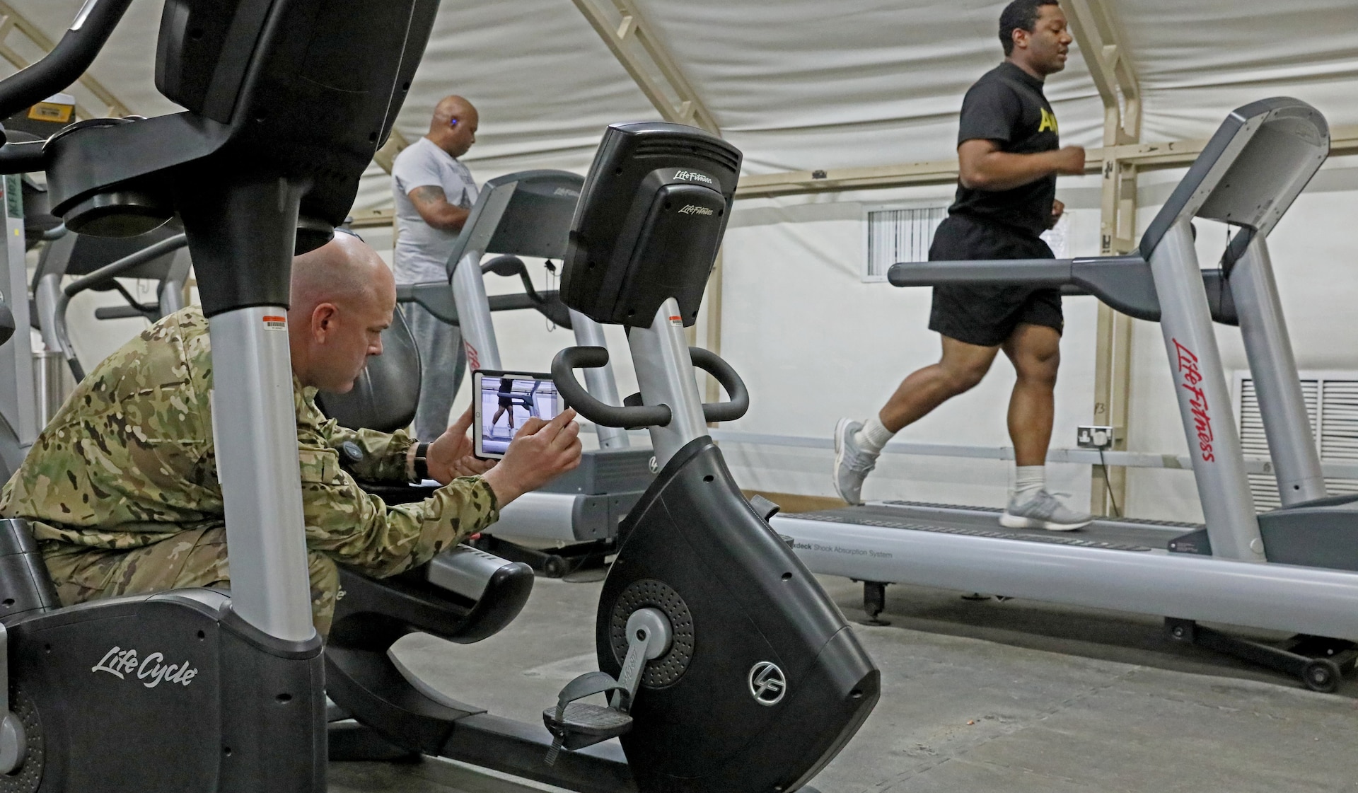 Cpt. Anthony Williams, left, 3rd Armored Brigade Combat Team physical therapist, uses his tablet to record video of Spc. Charles Becher of 1st Battalion, 66th Armor Regiment, 3ABCT, as he runs. Williams hosted a weekly running analysis class in order to help Soldiers identify issues that might be causing pain or injury.