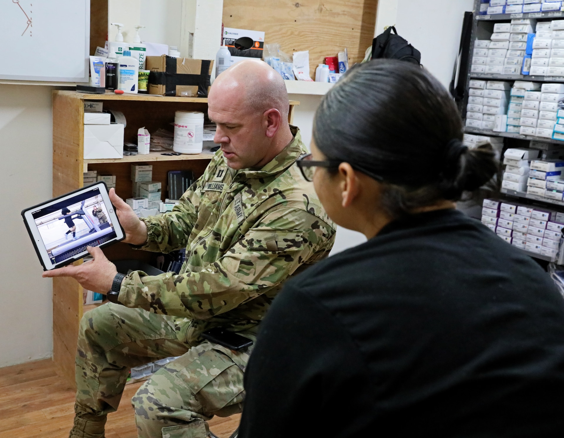 Cpt. Anthony Williams, left, 3rd Armored Brigade Combat Team physical therapist, shows Pfc. Kiyarra Flores, right, of 64th Brigade Support Battalion, 3ABCT, video of her running form during a gait analysis evaluation at Camp Buehring on Thursday, March 14, 2019. From the video, Williams was able to determine exactly at what angle Flores' foot struck the ground, and from there provided feedback to help prevent pain and injury due to running.
