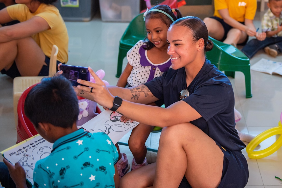 A sailor takes a picture of herself and a child.